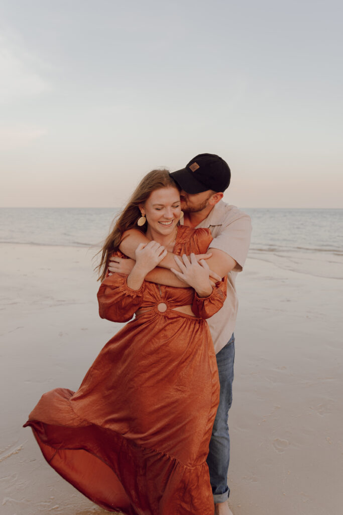 Couple hugging by the ocean during couples session