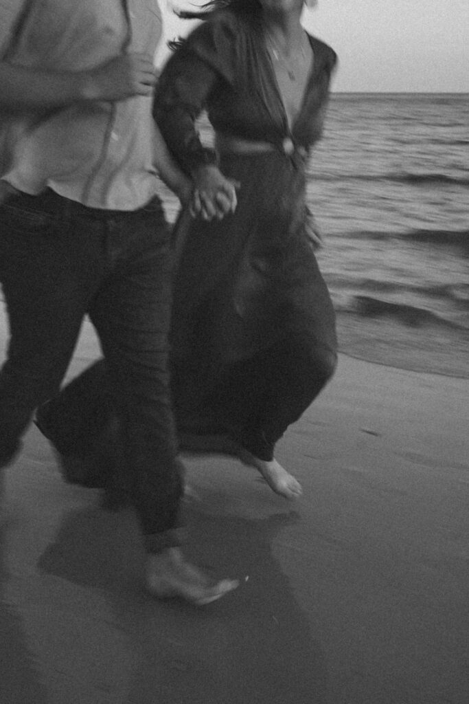 Couple running along the shore during couples session