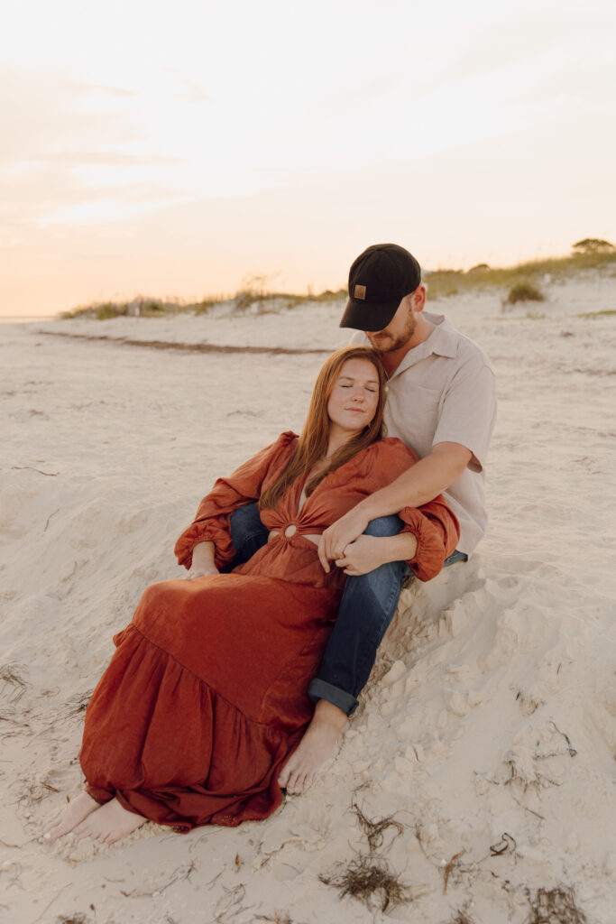 Couple sat in the sand during beach photoshoot at Alligator Point in Florida