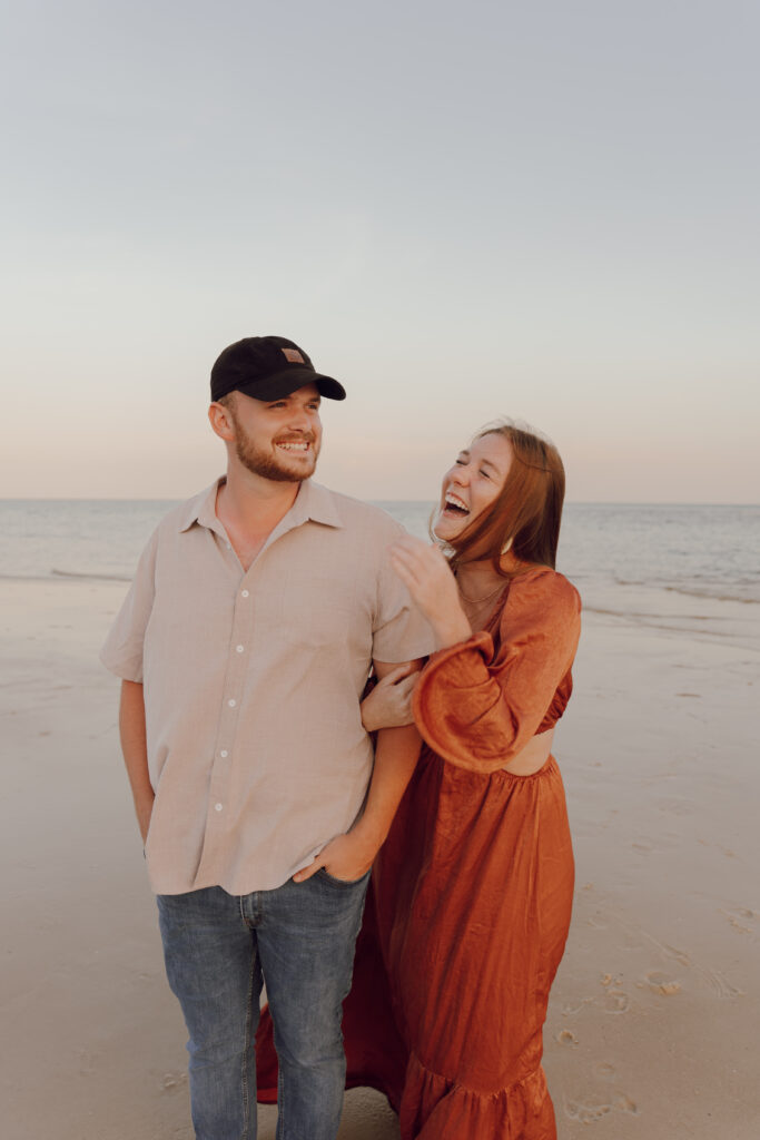 Couple laughing by the ocean during couples session