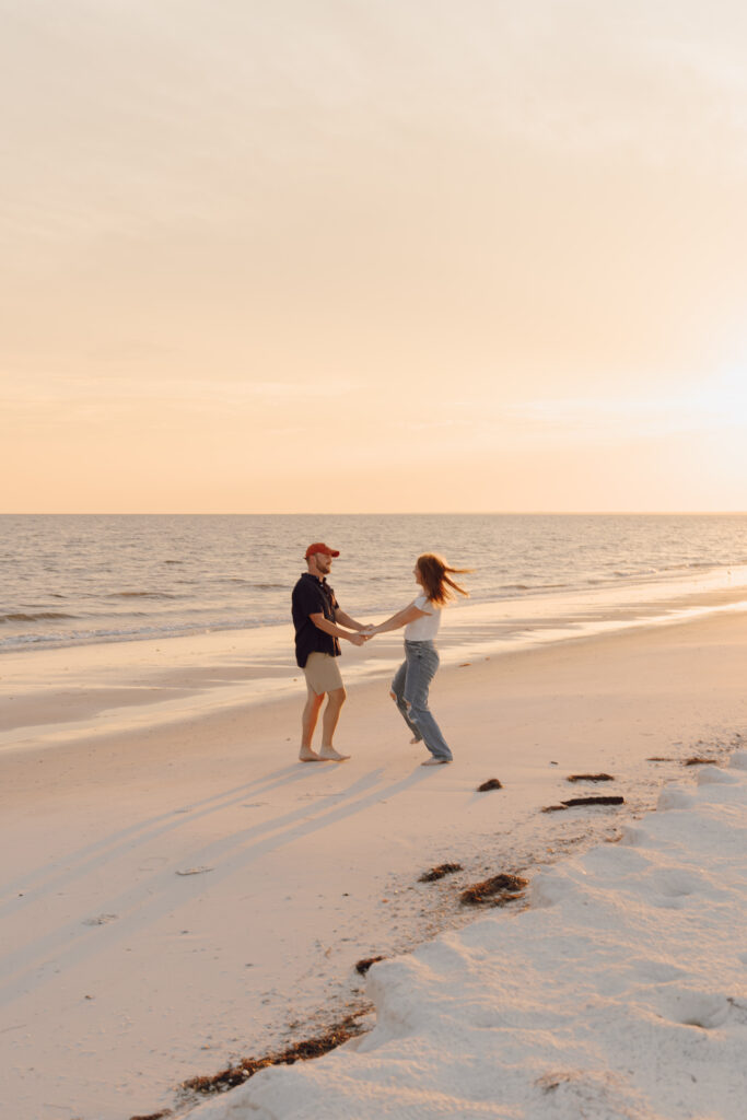 Couple dancing in the sand during beach photoshoot at Alligator point in Florida at Alligator Point in Florida