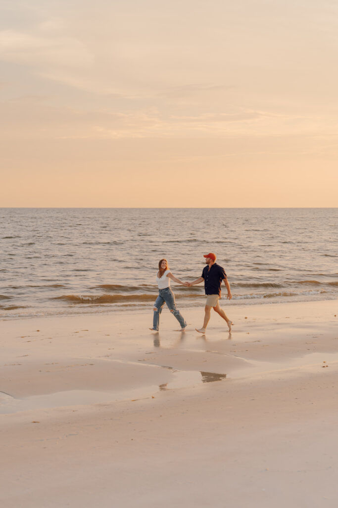 Couple walking along the sand during couples session at Alligator Point in Florida