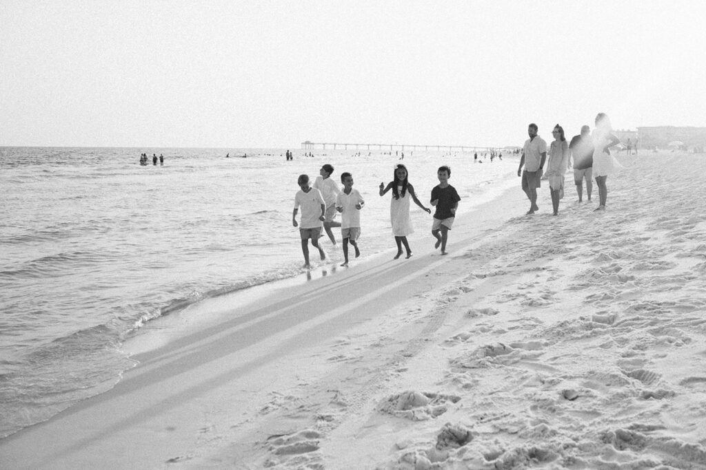 Kids running along the beach front