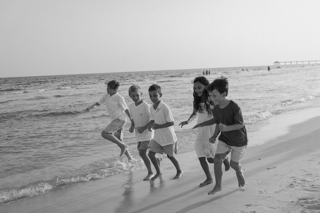 Chilrdren running along the beach at family photo session