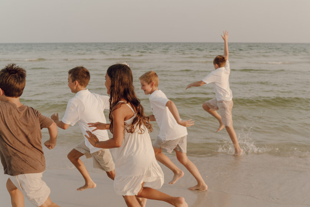 Chilrdren running along the beach at family photo session