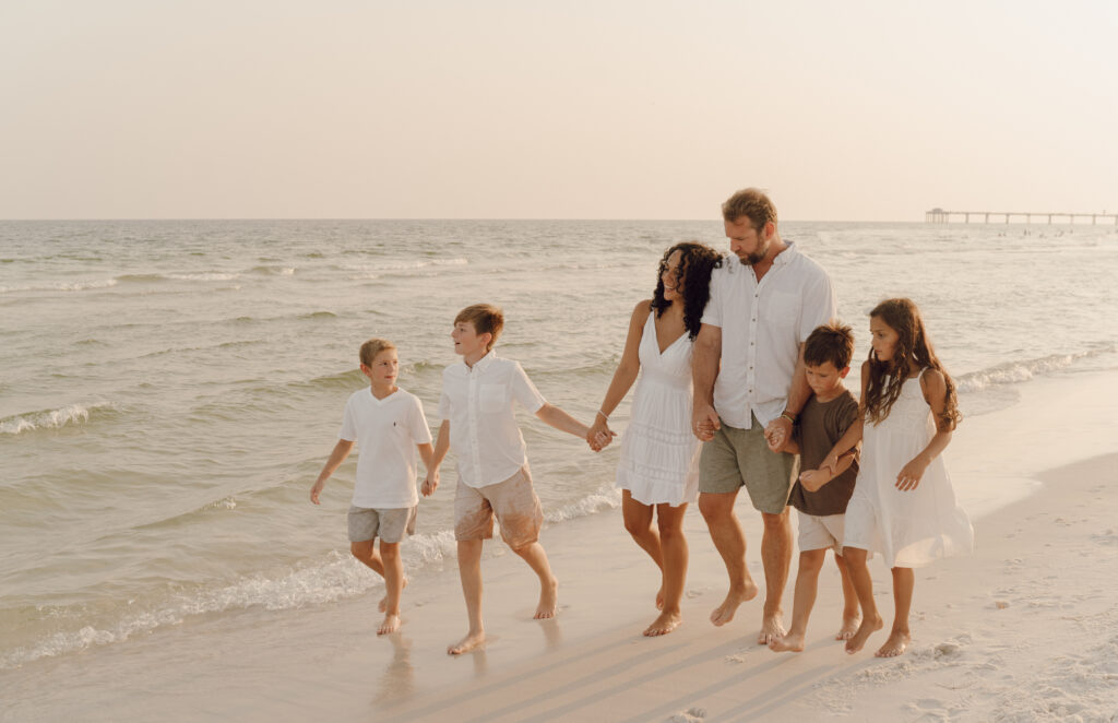 Family walking along the beach at family photo session at Destin Beach in Florida