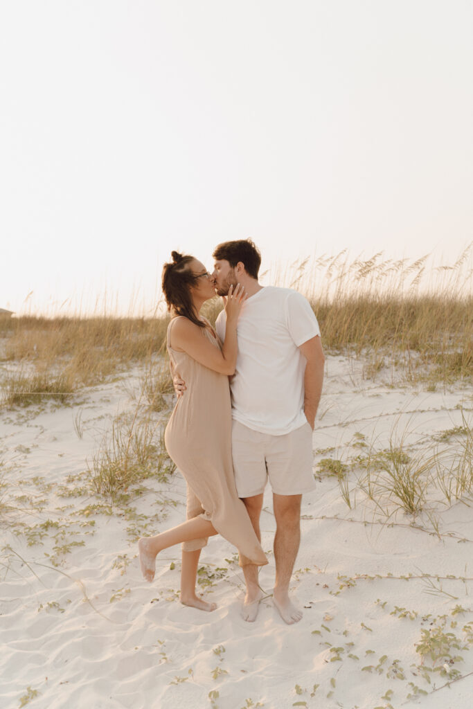 Couple kissing by the sea at family photo session at Destin Beach in Florida