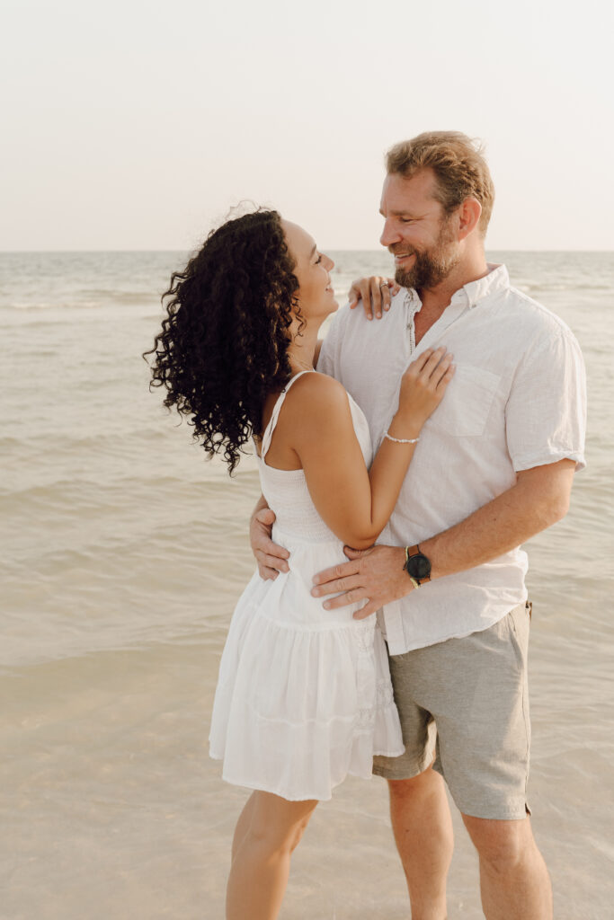 Couple hugging by the sea at family photo session