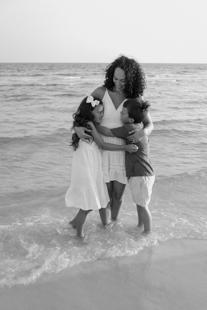 Mother and children playing in the sea