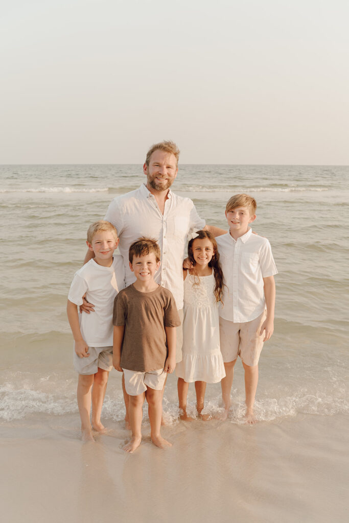 Dad and children smiling by the sea at Destin Beach in Florida