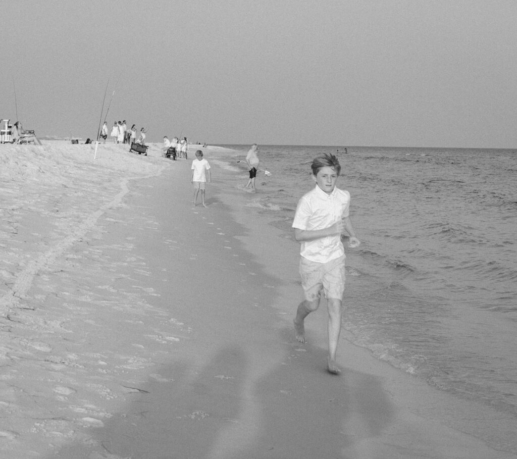 Kids running alongside the sea at Destin Beach in Florida