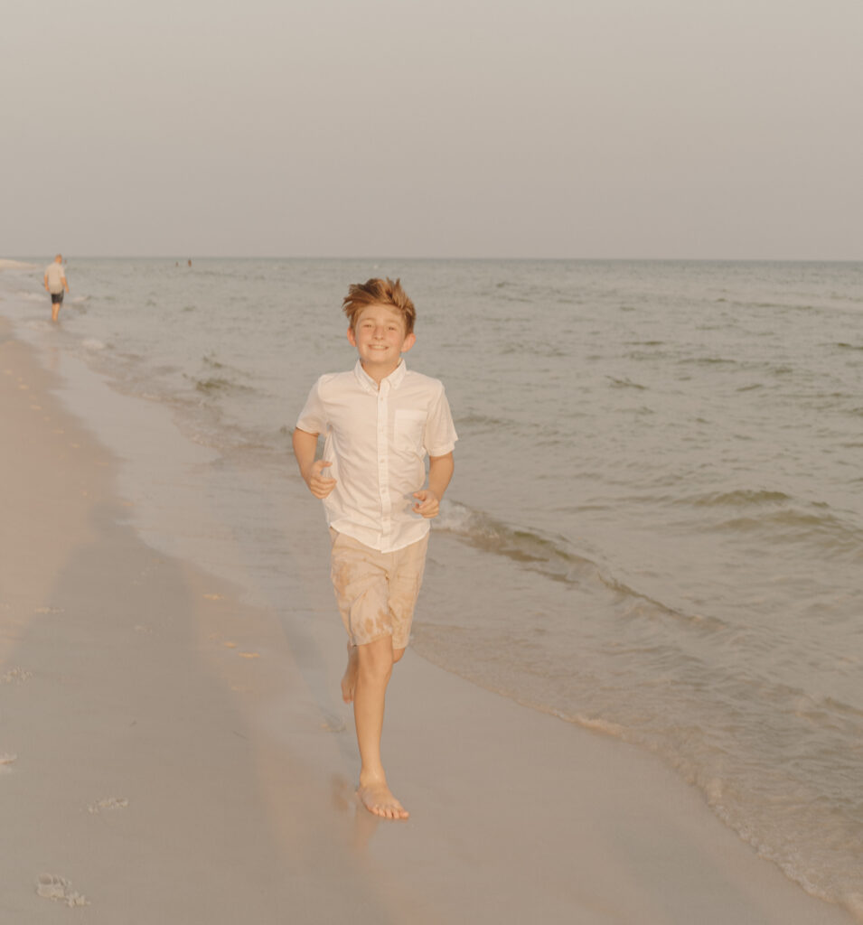 Boy running alongside the sea at Destin Beach in Florida