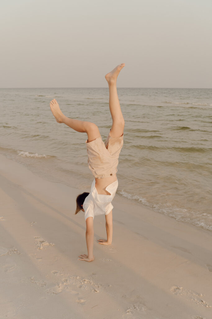 Boy doing handstand in the sea at Destin Beach in Florida