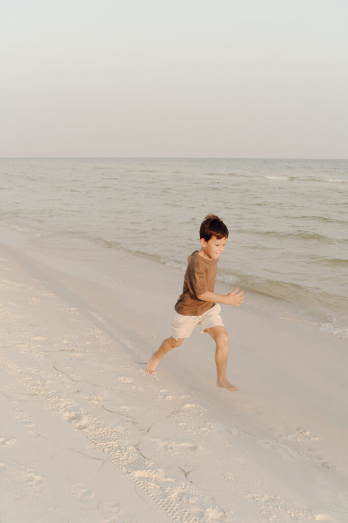 Kids running alongside the sea at Destin Beach in Florida