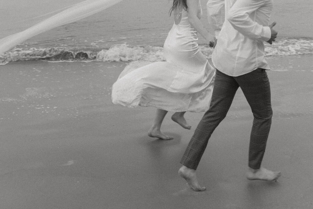 Couple running by the sea at Beach elopement at Folly Beach South Carolina