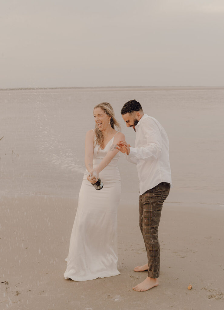 Couple drinking champagne at  Beach elopement at Folly Beach