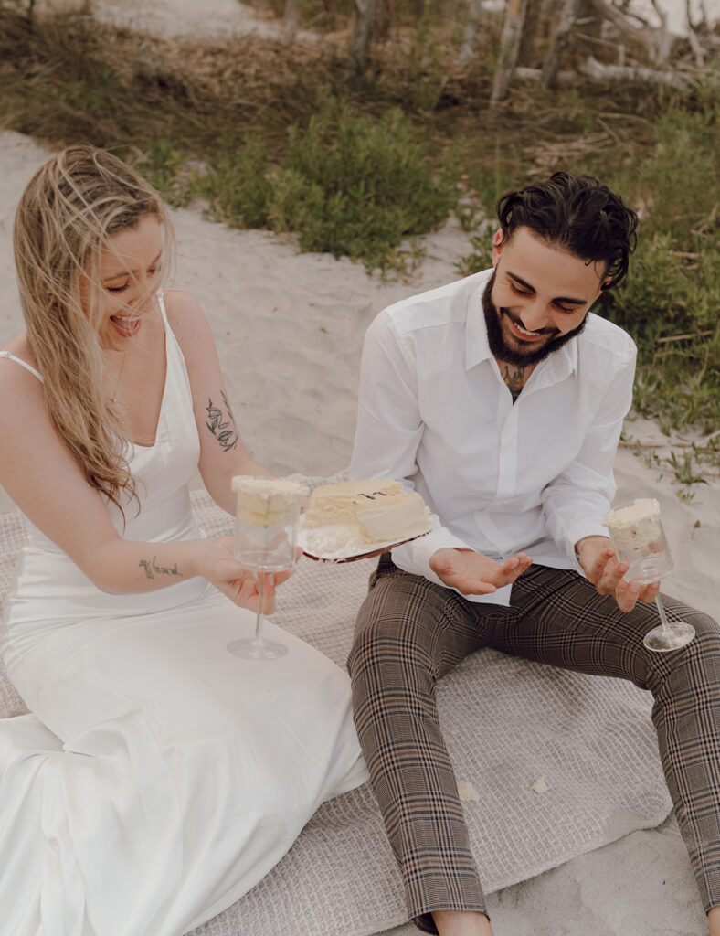 Couple eating cake at  Beach elopement at Folly Beach