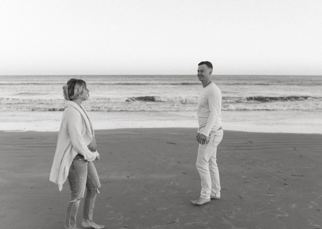 Couple walking on the beach during maternity shoot