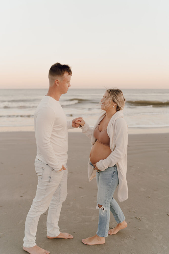 Couple holding hands during maternity shoot