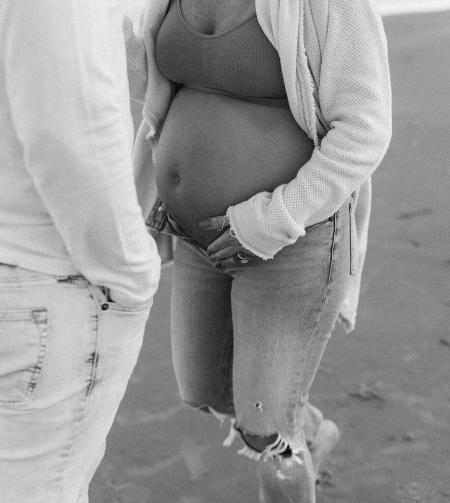 Couple holding baby bump at maternity shoot