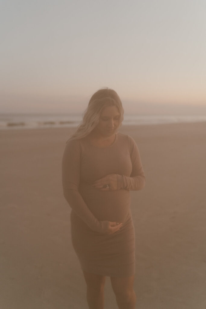 Mom to be holidng baby bump during maternity shoot