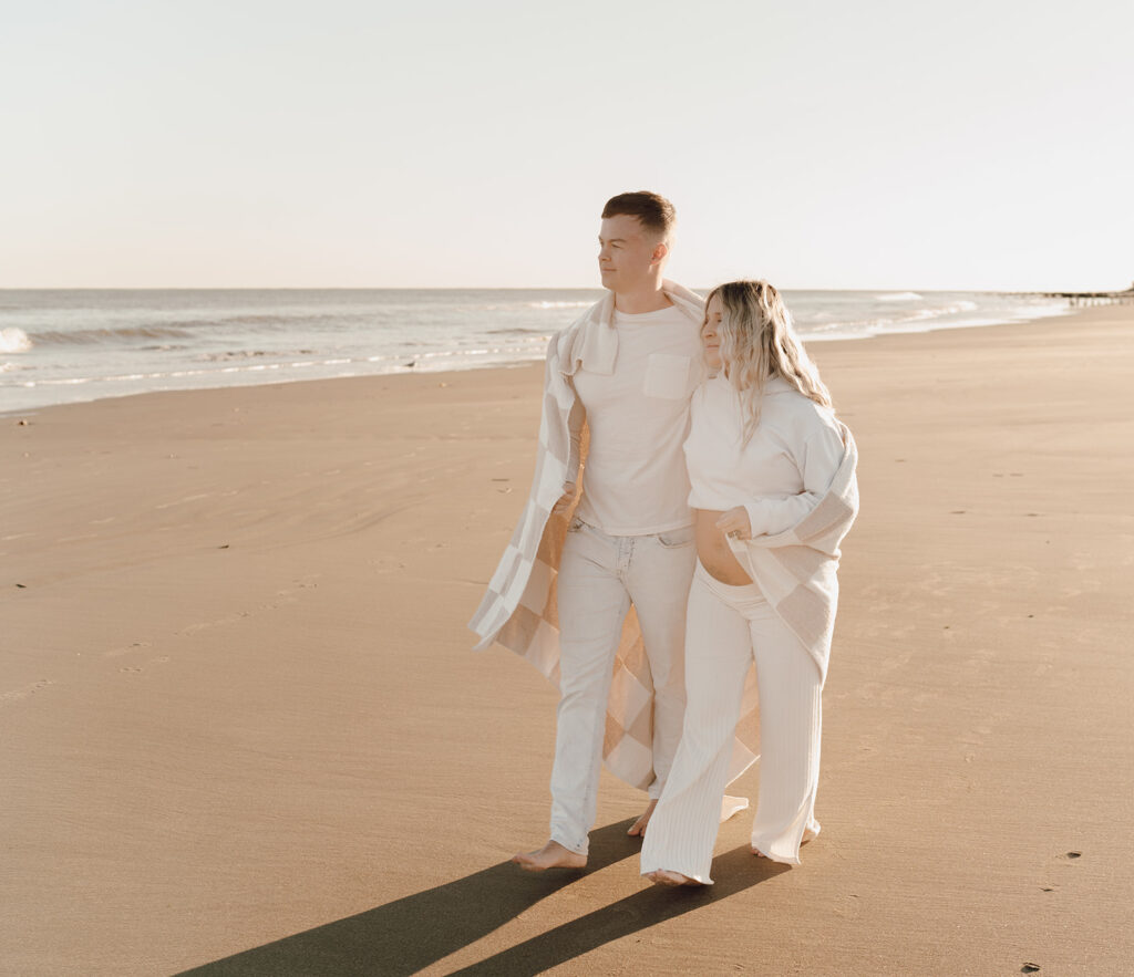 Couple walking on the beach during maternity shoot at Folly Beach Charleston