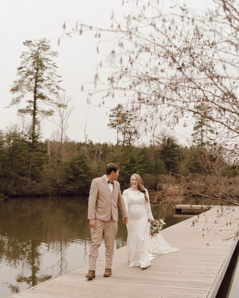 bride and groom walking along the dock of toccoa falls