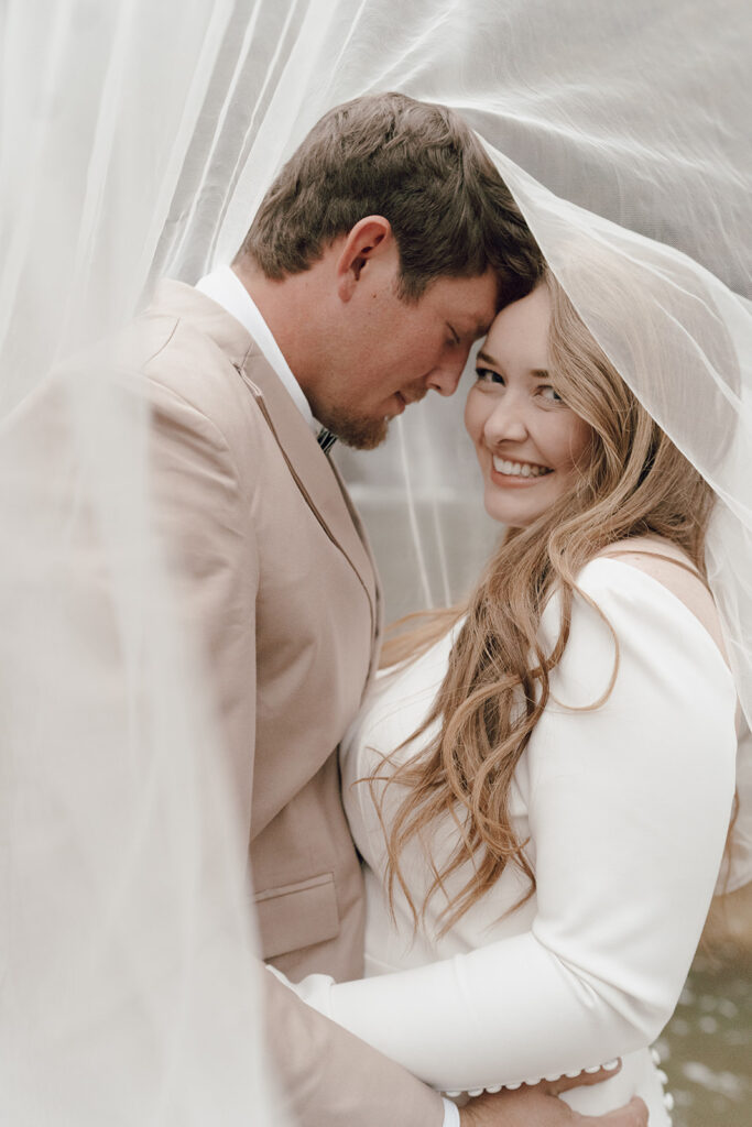 bride and groom under wedding veil