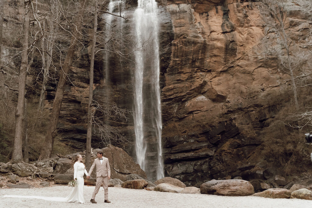 bride and groom standing under waterfall for destination elopement