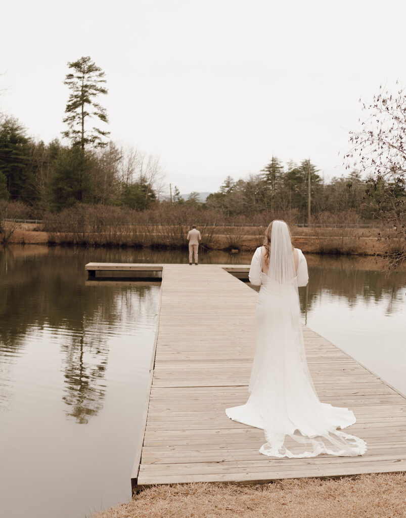 bride walking towards groom for first look on dock