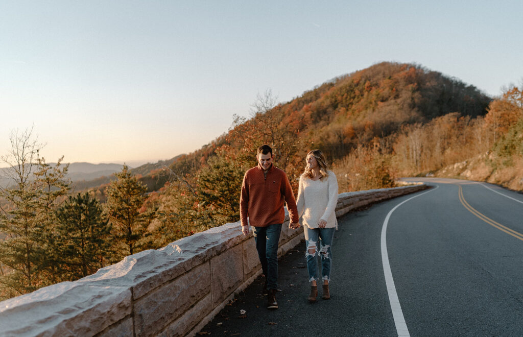 couple holding hands and walking on foothills parkway bridge