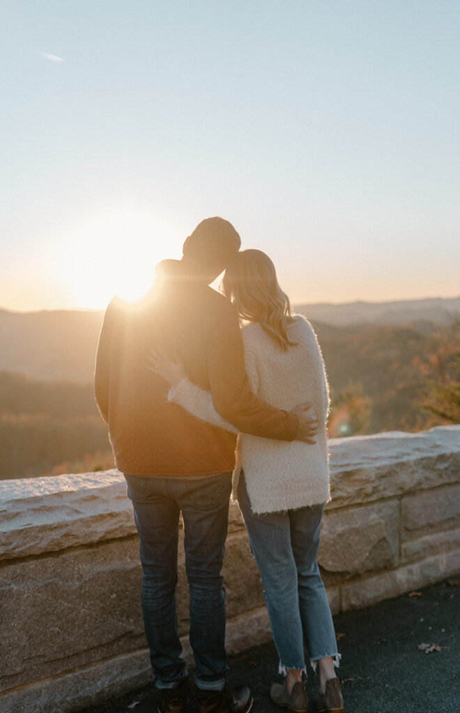 couple hugging and looking at the mountains in the distance