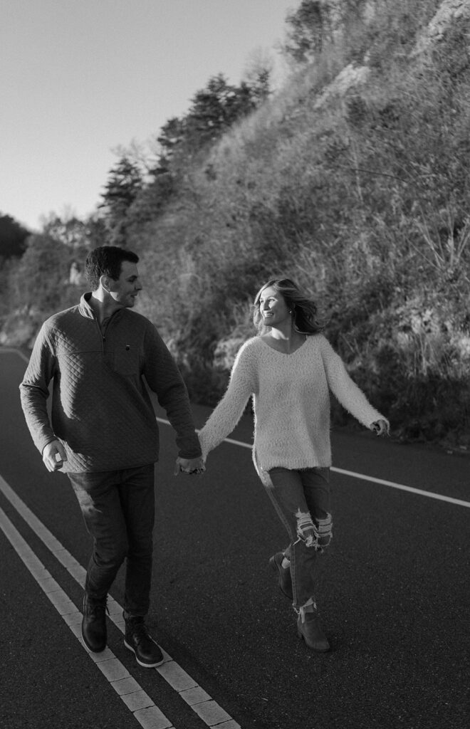 couple holding hands and running for smoky mountain engagement photos