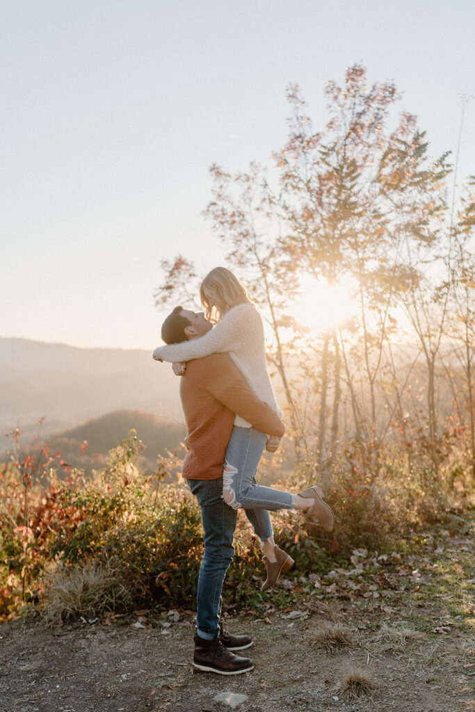 guy holding fiance up for smoky mountain engagement photos
