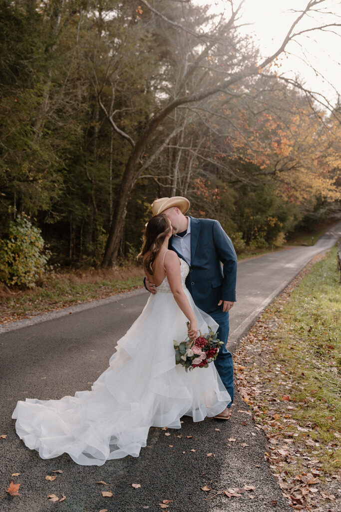 couple kissing under fall foliage for elopement