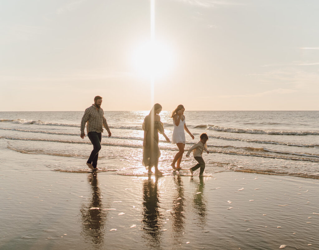 family walking in the water on the beach