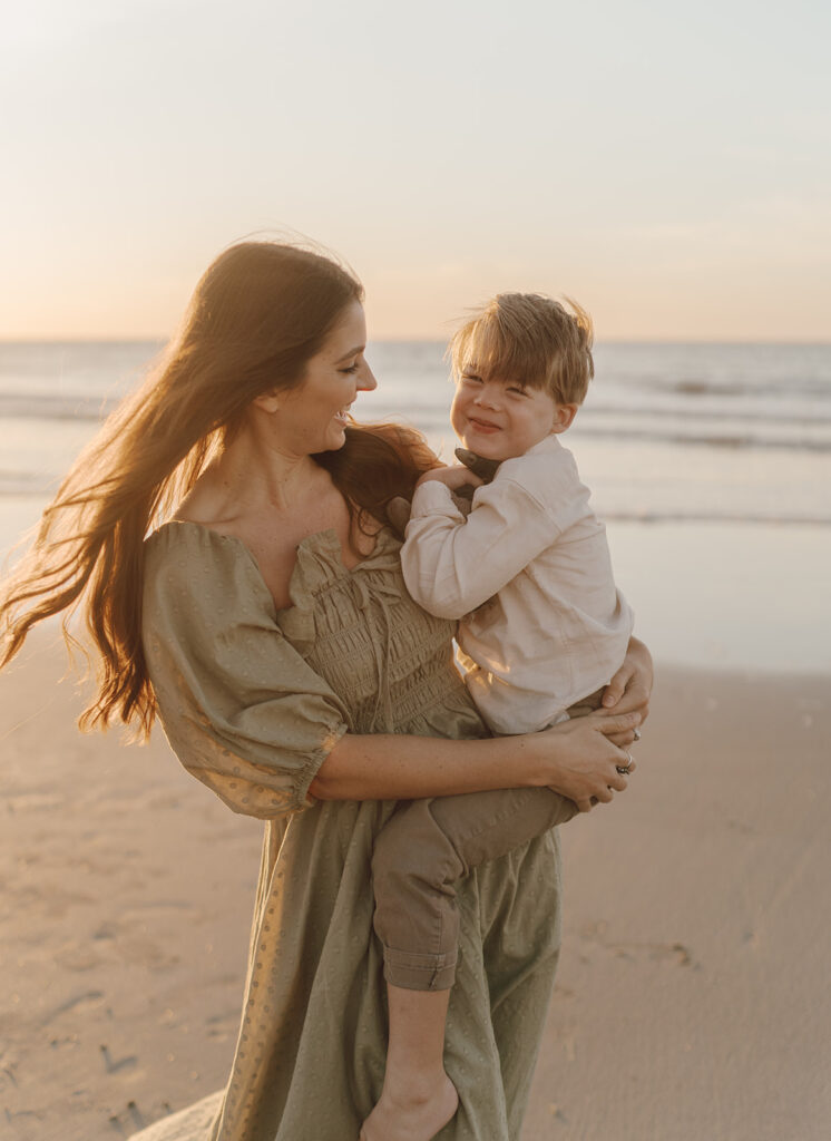 mom holding toddler son on folly beach
