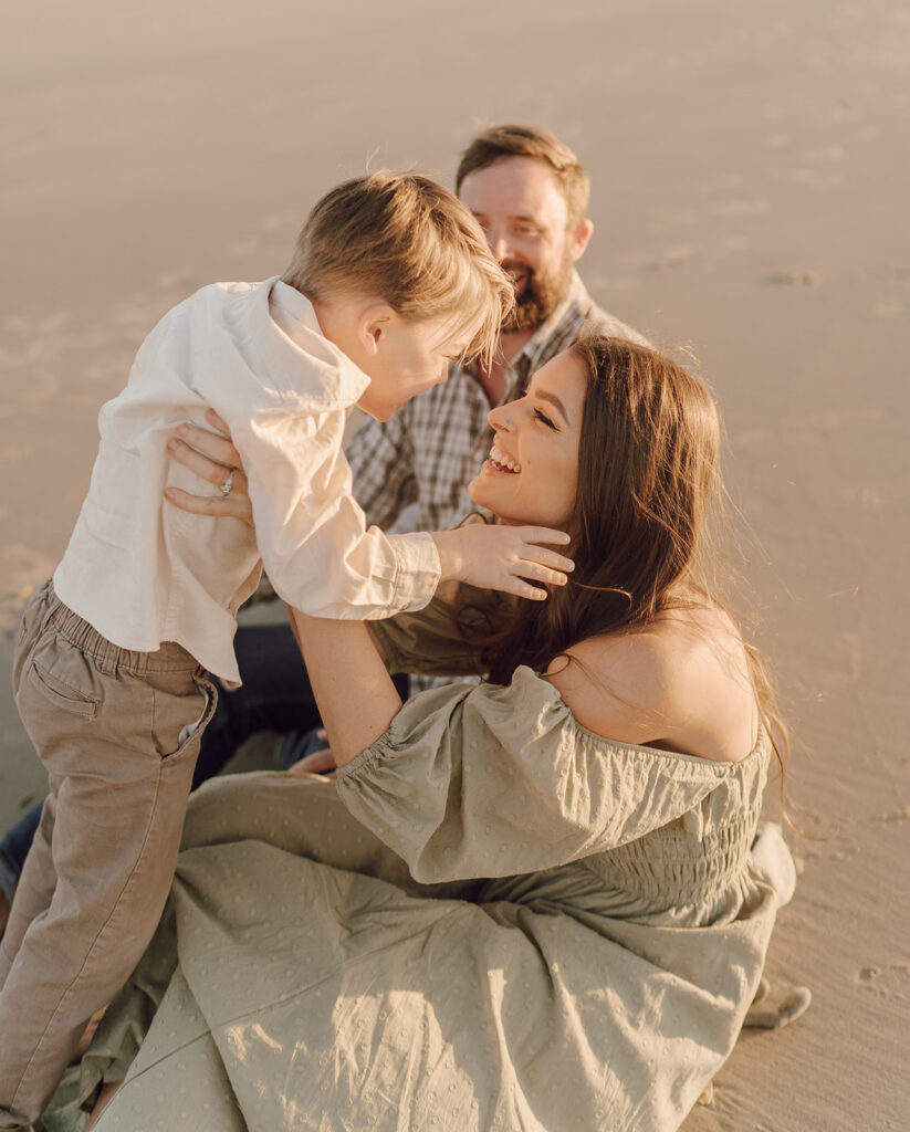 mom and son smiling with dad for beach family pictures