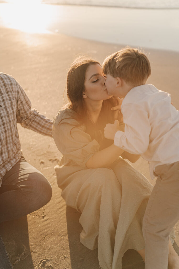 mom kissing son for beach family pictures