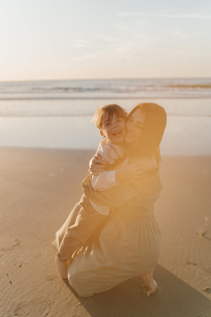 mom and son hugging during sunrise on the beach