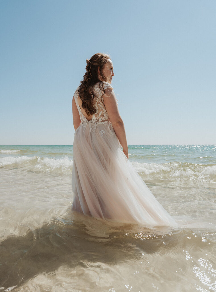 bride standing alone shoreline for trash the dress photoshoot
