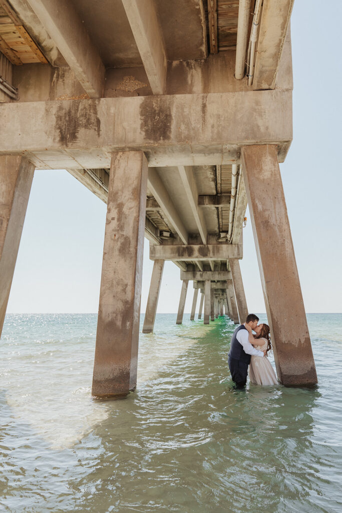 bride and groom standing in the water and kissing