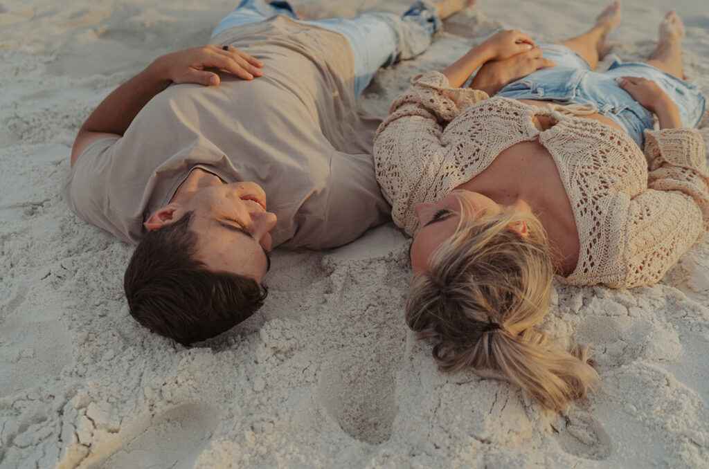 couple laying on the sand at seaside fl 30A photographer