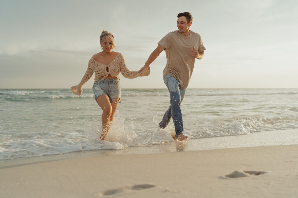 couple running on the beach and holding hands 30A photographer