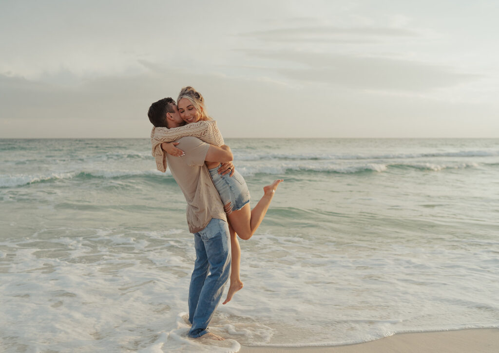 couple laughing and candidly posing on the beach