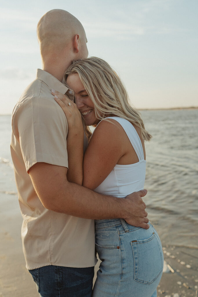 couple smiling and hugging folly beach engagement photos 