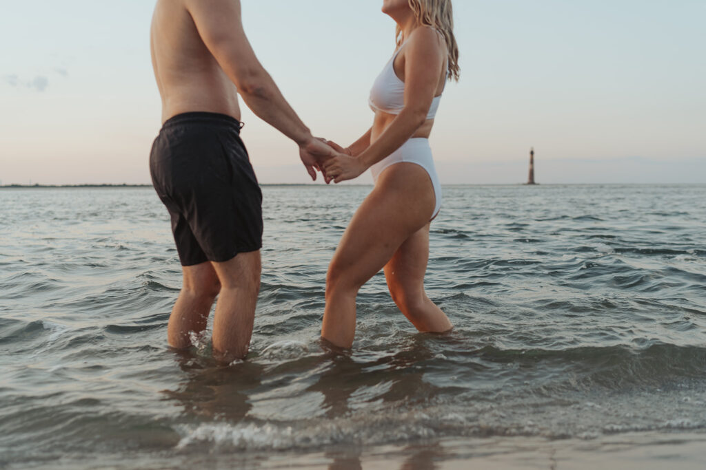couple playing in the water on folly beach during engagement session