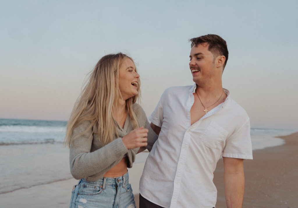 couple laughing at the beach during couple session