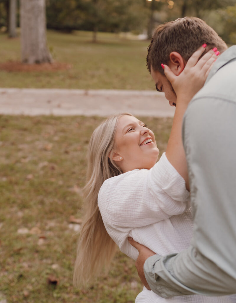 couple smiling candid poses for engagement photos in florida