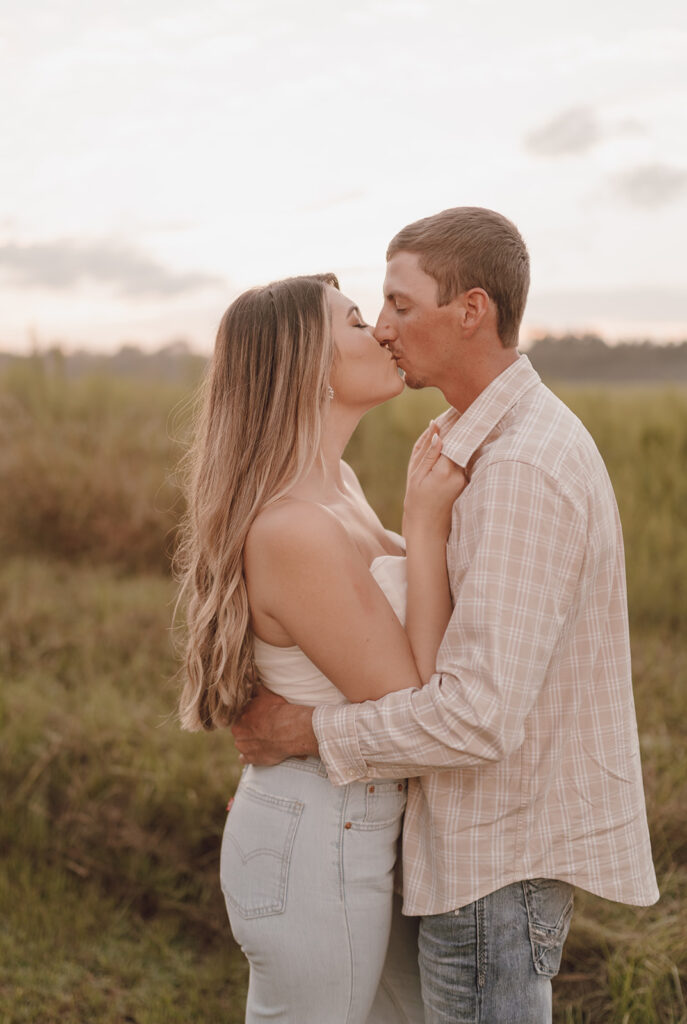 couple kissing neutral engagement outfits